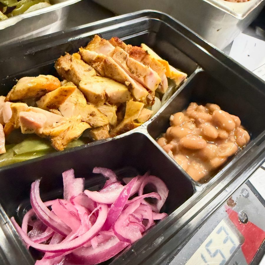 Culinary Curators meal prep box of grilled chicken, beans and pickled onions on a kitchen scale
